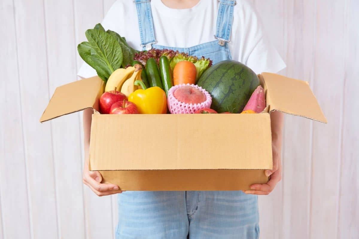 Woman with a box of fruit and veggies
